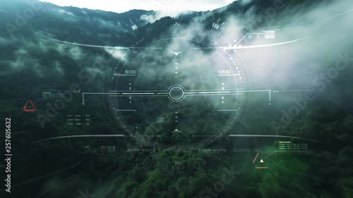 Aerial view from the fighter plane's cockpit flying over the low cloud cover mountain scape with head up display acquire targets and enemies location hidden in the dense mountain forest photo