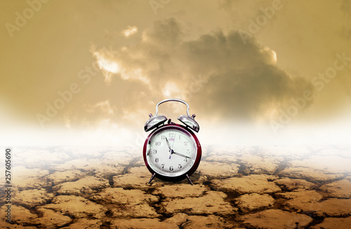 Photography Time of adversity concept, Alarm clock with dry land background