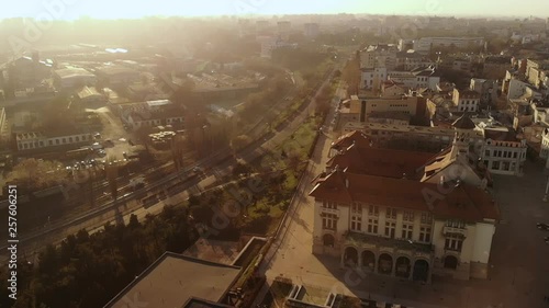 Lift drone in slow motion of the Old Town of Constanta, Romania, Europe. Shot in spring during sunset and Golden Hour, revealing the History Museum, city's architecture and traffic, while seagulls fly photo