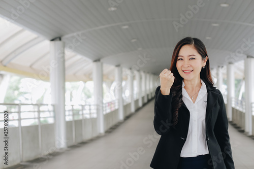 Successful and confident asian senior businesswoman leader standing over modern pathway background