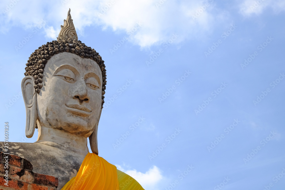 Worm eye perspective view Lord Buddha statue, closeup on head part, outdoor, on the cloudy blue sky background, with copy space Worm eye perspective view Lord Buddha statue, closeup on head part, outdoor, on the cloudy blue sky background, with copy space