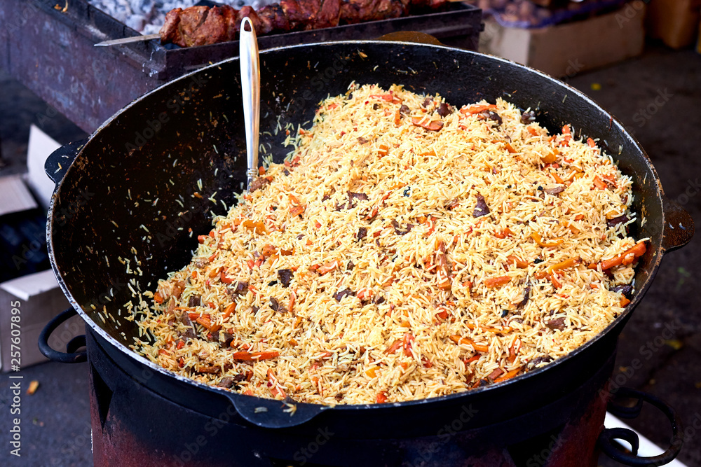 Cooking armenian pilaf dish in outdoor. pilaf in a cauldron, street food Cooking armenian pilaf dish in outdoor. pilaf in a cauldron, street food