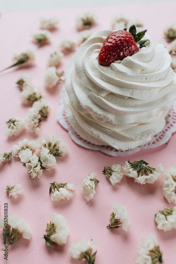 Fresh dessert with whisked cream and strawberry and flowers on table Fresh dessert with whisked cream and strawberry and flowers on table
