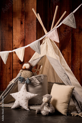 tipi zelt im kinderzimmer vor brauner holzwand photo