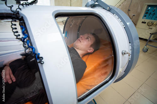 young guy in a hyperbaric chamber, oxygen treatment, medical chamber