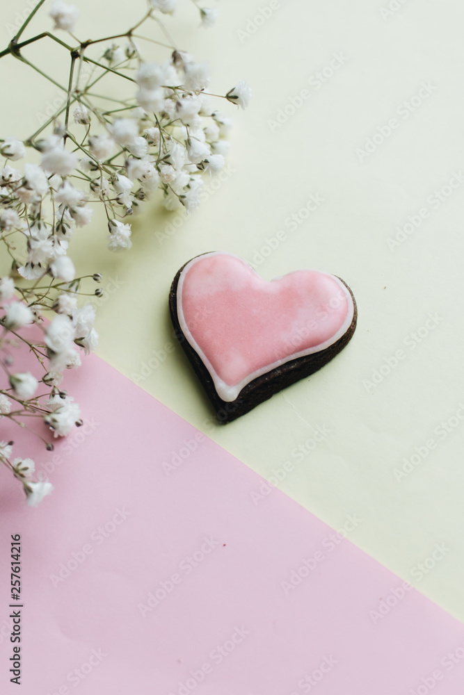 Cookie in heart shape with red glaze and white flowers Cookie in heart shape with red glaze and white flowers