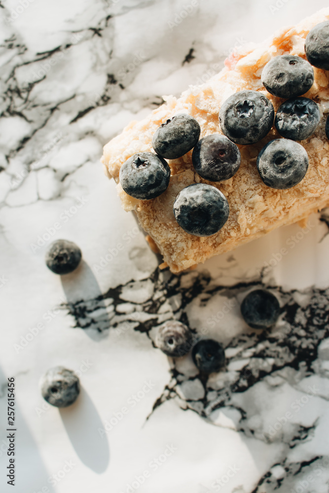 Piece of delicious cake with blueberries on marble table, sweet dessert Piece of delicious cake with blueberries on marble table, sweet dessert