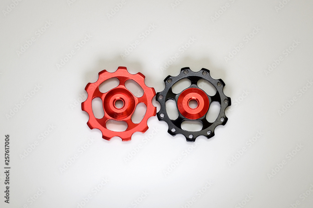 Black and red rollers, gear for bicycle rear derailleur on white background