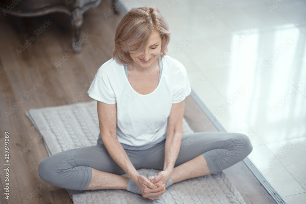 Mature woman sitting on the floor in lotus position