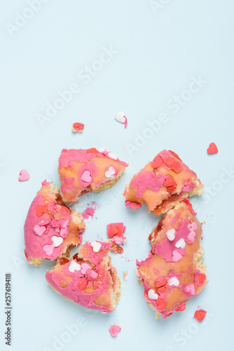 Pink donut with heart sprinkles smashed in to pieces. Valentine's day glazed donut love breakup concept.