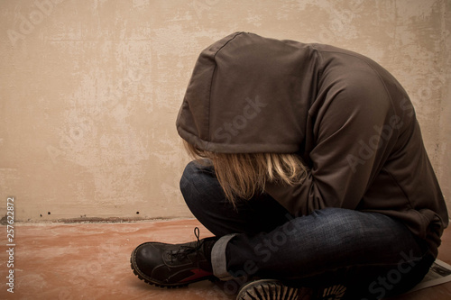 Portrait of man sad, drug addict man sitting on the floor in corner