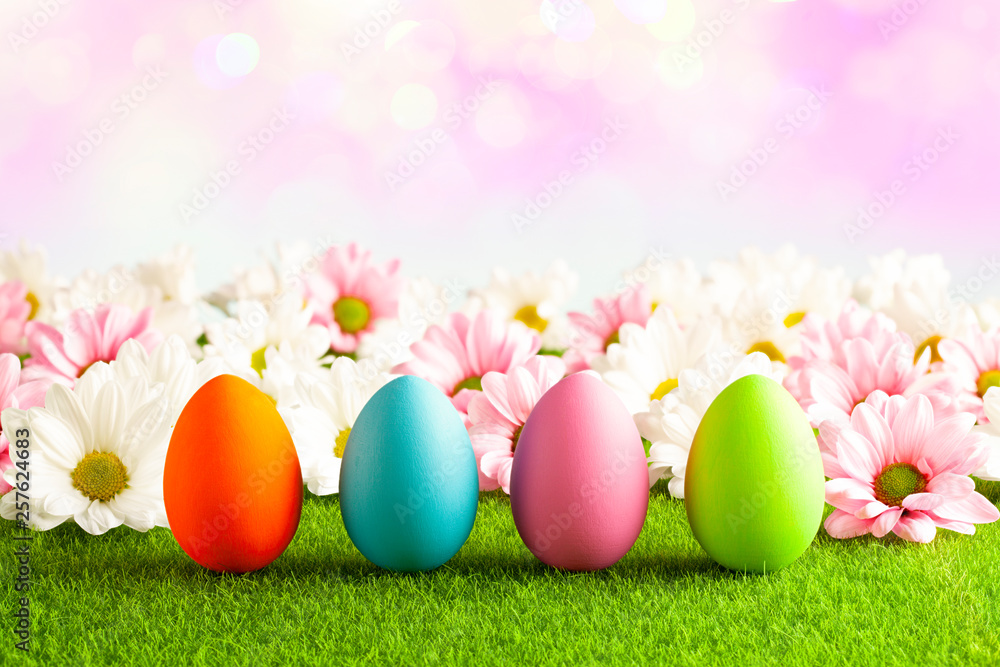 Easter eggs on the grass and pink abstract background