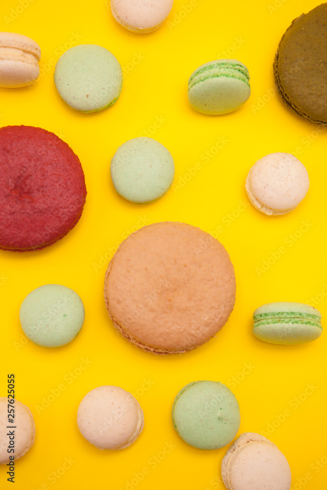 Delicious big caramel macaroon flavour next to cherry macaroon over yellow background Delicious big caramel macaroon flavour next to cherry macaroon over yellow background