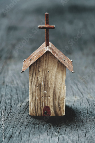Small wooden church model on wooden background, still life photography with selective focus narrow depth of field on the church photo