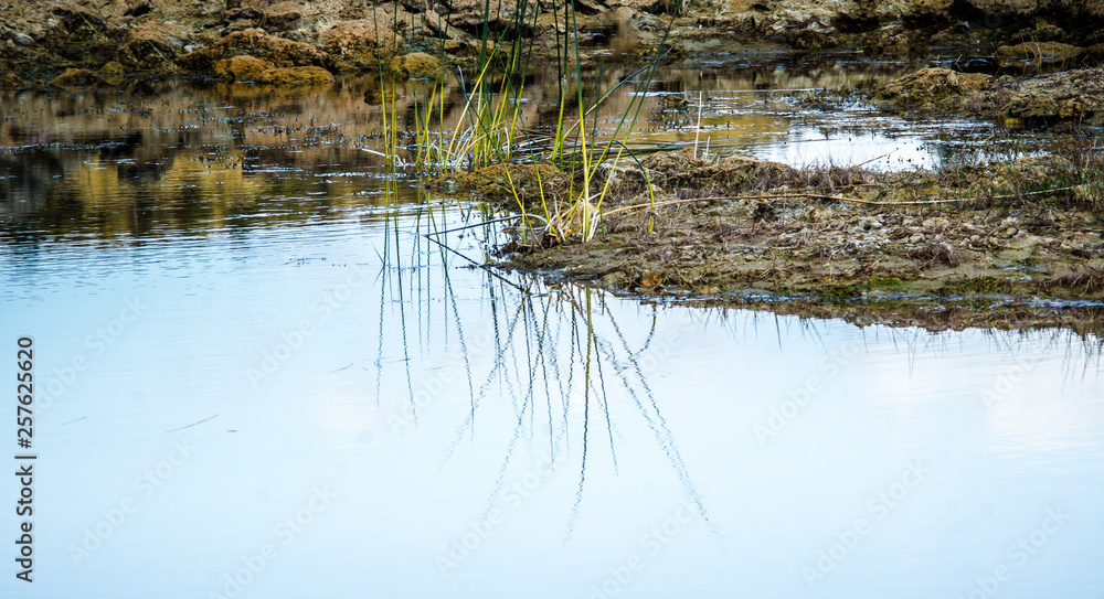 Sandy hills. Lake in the Sandy canyon. Warm colors background. Yellow sandstone textured mountain, white thin sand dune, bright sky. Sunshine landscape Sandy hills. Lake in the Sandy canyon. Warm colors background. Yellow sandstone textured mountain, white thin sand dune, bright sky. Sunshine landscape