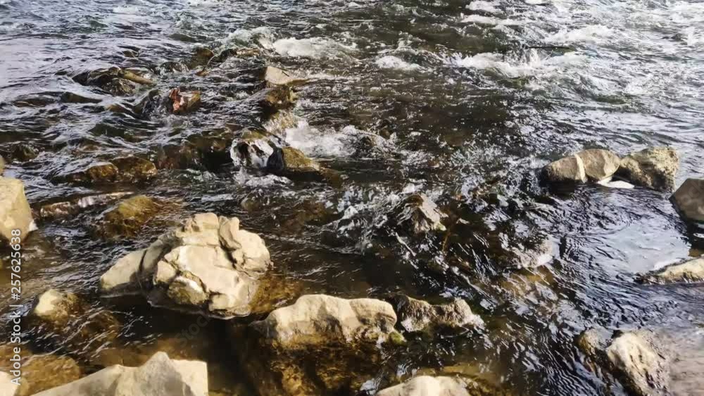 Water calmly running over rocks in a creek. Water calmly running over rocks in a creek.