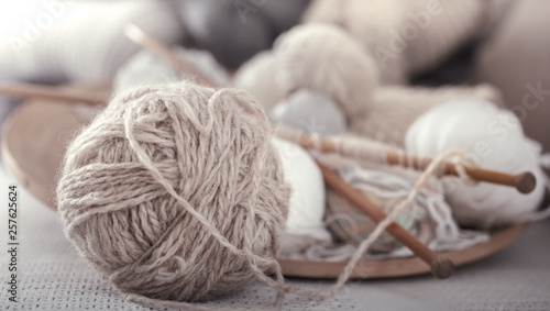 Vintage wooden spokes and threads for knitting in the shape of a heart on a wooden plate. Still life photo