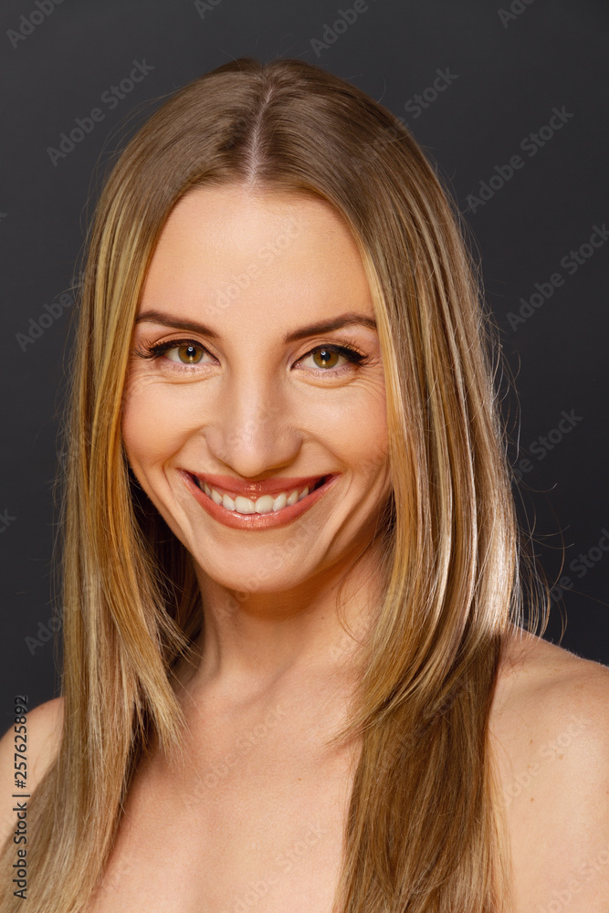 Fototapeta premium Portrait einer lächelnden Frau auf schwaryem Hintergrund
