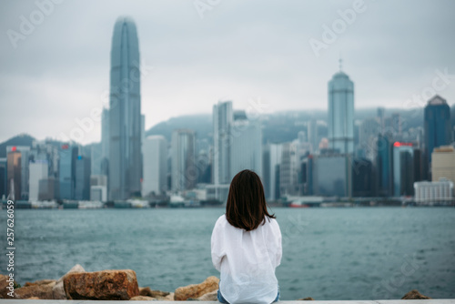 Canvas Print Young woman traveler is sitting looking cityscape view of Hong Kong China