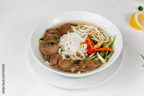 Traditional oriental cuisine of Vietnam. Pho bo soup with rice noodles, beef, pepper, wheat germ, greens