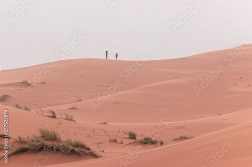 People walk on the dunes of the Sahara desert, Merzouga Morocco.