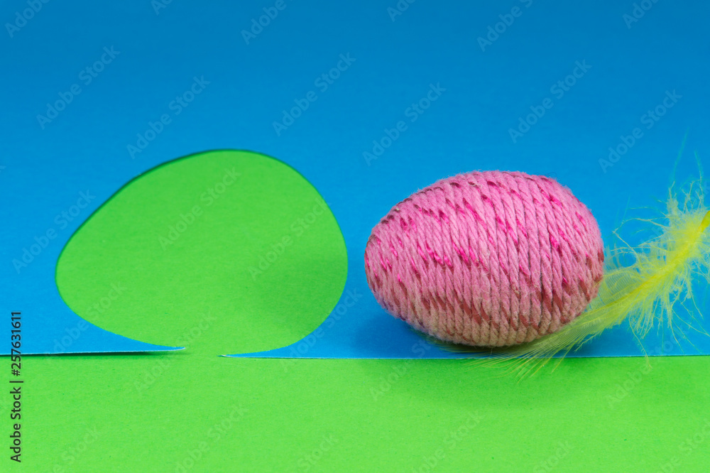 Easter egg, feather and cutout of blue paper Easter egg, feather and cutout of blue paper