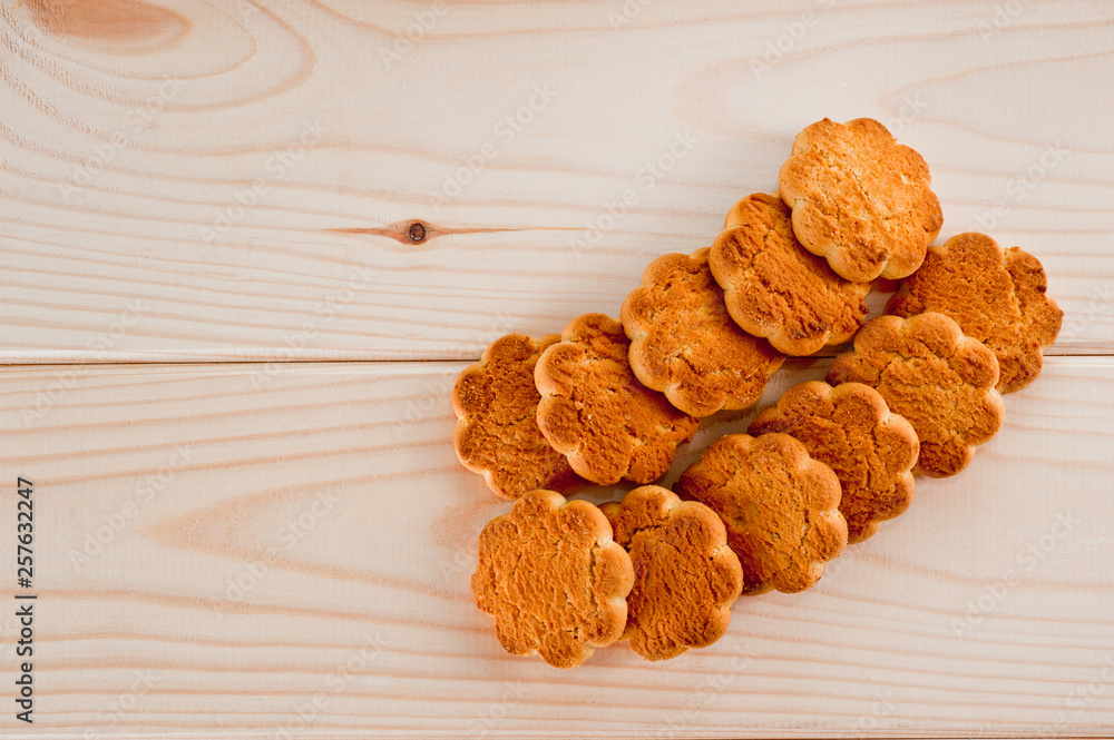 Fototapeta premium Tasty and beautiful cornflakes cookies among of corn flakes on a wooden table as background, top view