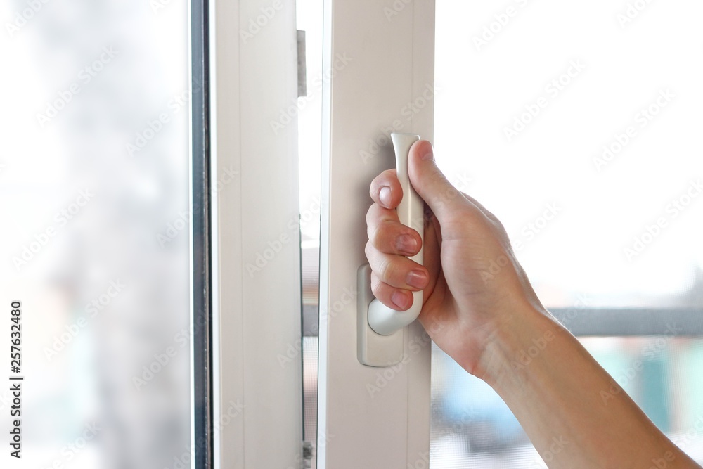 A man's hand opens a white plastic window. Close up A man's hand opens a white plastic window. Close up