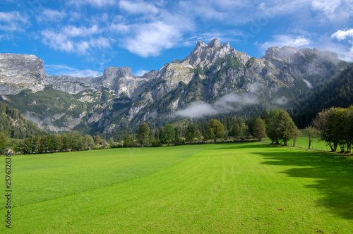 Austrian Verfenveg village Alps mountains autumnal scenery with fog, green meadows and rocks