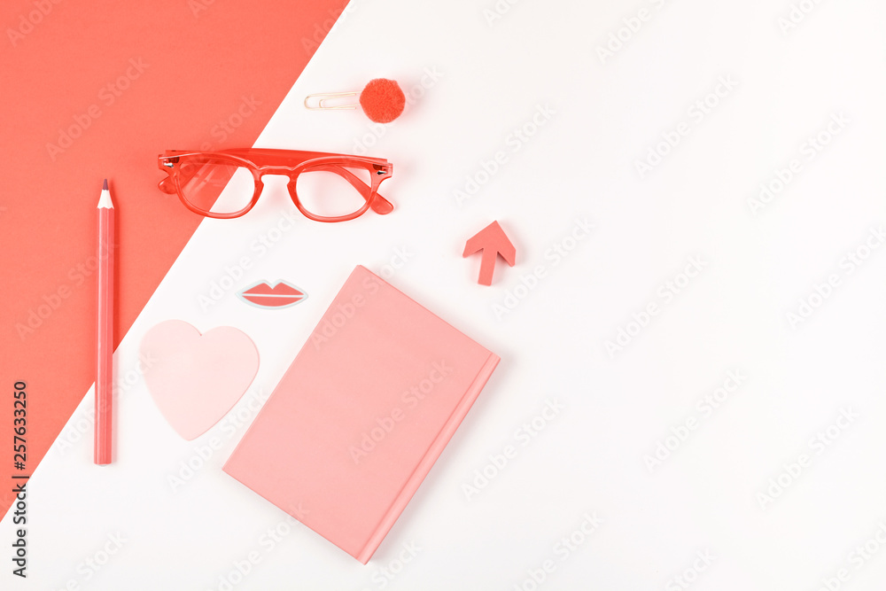 Top view of workspace with coral bullet journal, glasses and blogger accessories Top view of workspace with coral bullet journal, glasses and blogger accessories