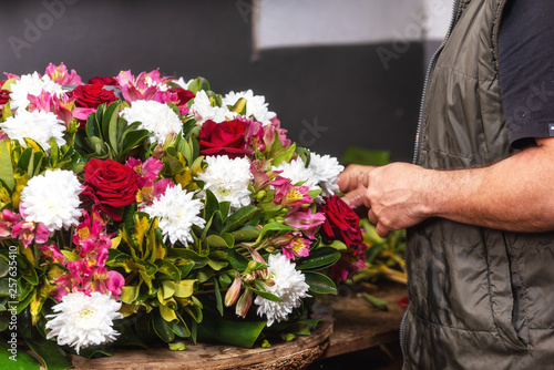 Bloemist aan het werk. Mannelijke bloemist die mooi boeket maakt bij bloemenwinkel. Detailopname.