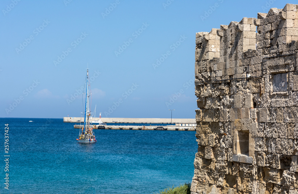 yacht on the Mediterranean sea, old fortress wall, Rhodes, Greece