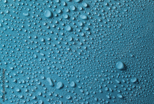 Drops of water on a blue glass texture background