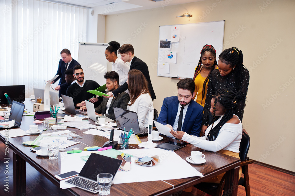 Multiracial young creative people in modern office. Group of young business people are working together with laptop, tablet. Successful freelancers team in coworking. Multiracial young creative people in modern office. Group of young business people are working together with laptop, tablet. Successful freelancers team in coworking.