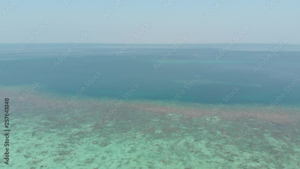 Aerial: flying over coral reef tropical caribbean sea turquoise blue water white beach. Indonesia Kei islands, Moluccas. Top travel destination, diving snorkeling. Native cinelike D-log color profile Aerial: flying over coral reef tropical caribbean sea turquoise blue water white beach. Indonesia Kei islands, Moluccas. Top travel destination, diving snorkeling. Native cinelike D-log color profile