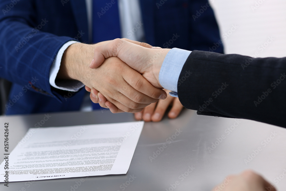 Business people shaking hands, finishing up a papers signing. Meeting, agreement and lawyer consulting concept
