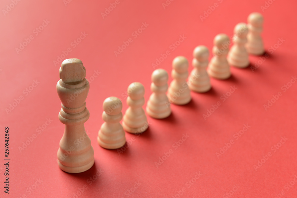 Big chess piece among small ones on color background. Concept of uniqueness Big chess piece among small ones on color background. Concept of uniqueness