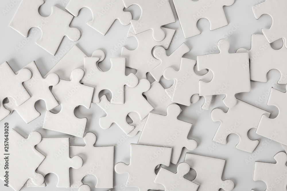 Heap of white puzzle pieces on light background Heap of white puzzle pieces on light background