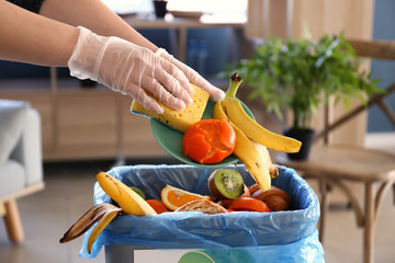 Woman throwing garbage into trash bin