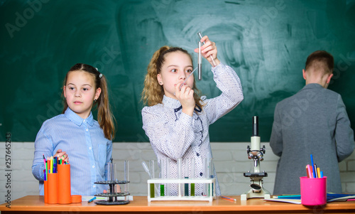 Children study biology or chemistry school. School education. School girls study. Kids in classroom with microscope and test tubes. Explore biological molecules. Future technology and science concept