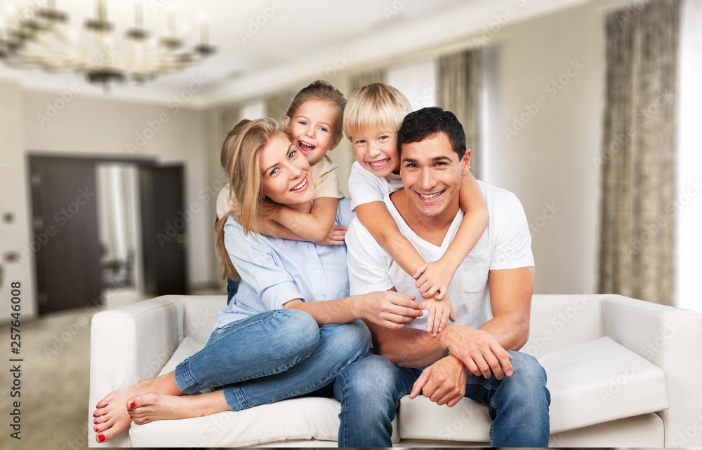 Beautiful smiling family sitting at sofa at home Beautiful smiling family sitting at sofa at home