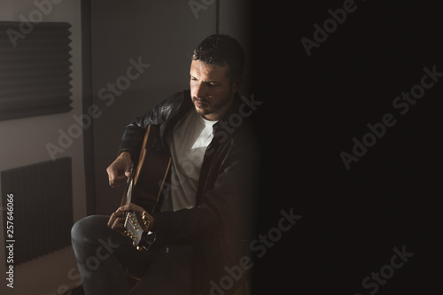 Young man with a classical guitar indoors. Concept Musician guitarist