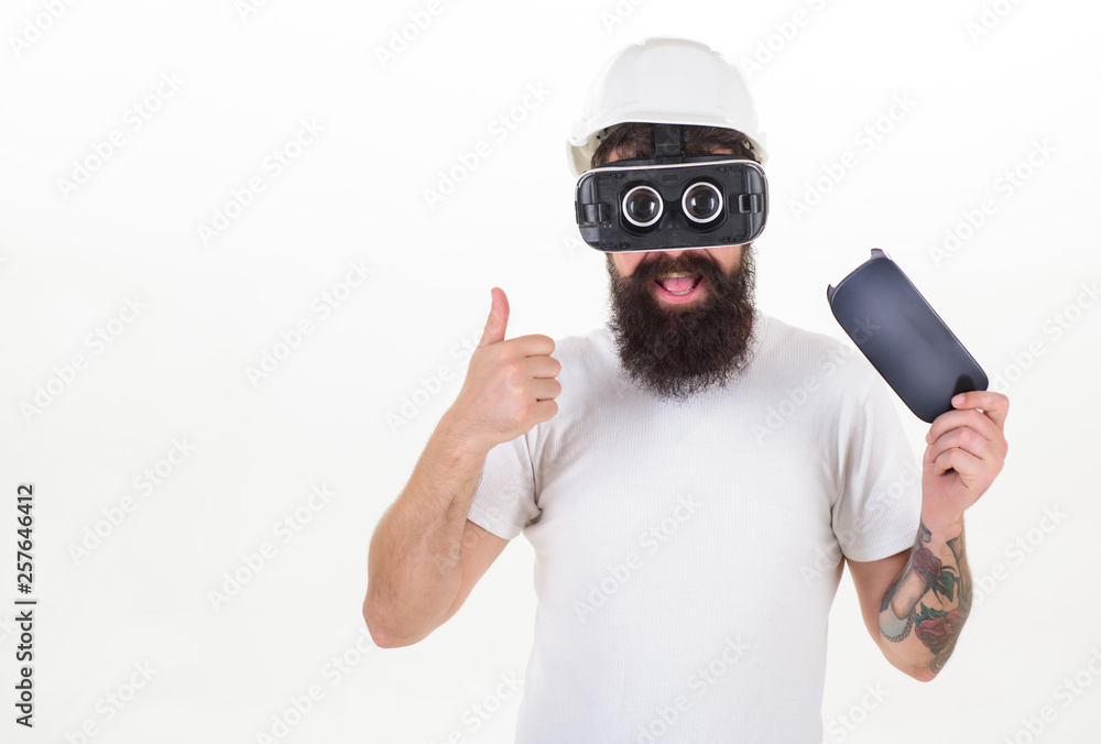 Bearded man wearing virtual reality goggles in studio. Portrait of young man wearing vr goggles, experiencing virtual reality using 3d headset. Future technology concept. Bearded man wearing virtual reality goggles in studio. Portrait of young man wearing vr goggles, experiencing virtual reality using 3d headset. Future technology concept.