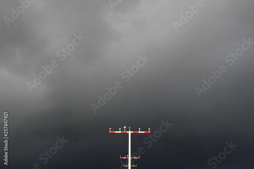 Mast für Befeuerung an der Landebahn Nordwest am Flughafen Frankfurt und dunkle Wolken - Stockfoto
