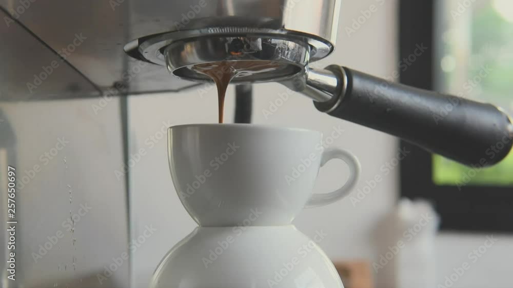 Barista using coffeemaker extraction for espresso shot in cafe. Barista using coffeemaker extraction for espresso shot in cafe.