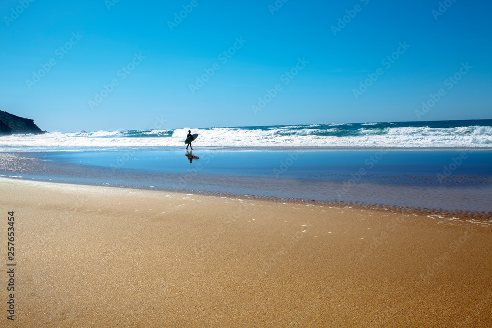 Surfista adentrándose en el mar