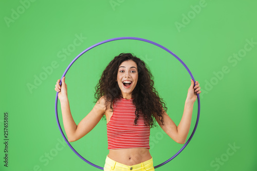 Quadro su tela Photo of energetic woman 20s wearing summer clothes doing exercises with hula ho