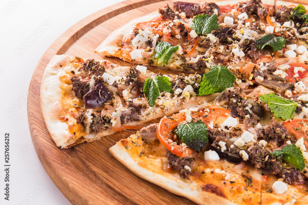 Pizza with mint on a wooden circular board isolated on white background Pizza with mint on a wooden circular board isolated on white background