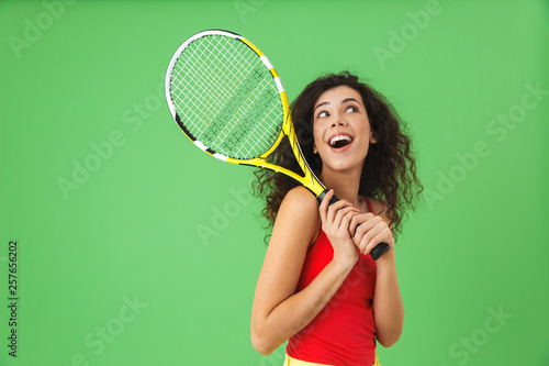 Image of attractive female tennis player 20s smiling and holding racket © Drobot Dean