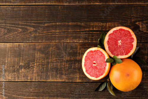 Citrus fruit. Fresh grapefruit with leaves on a brown wooden table. top view. free space